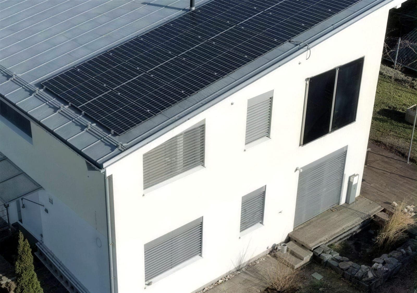White family home with panels on a flat roof