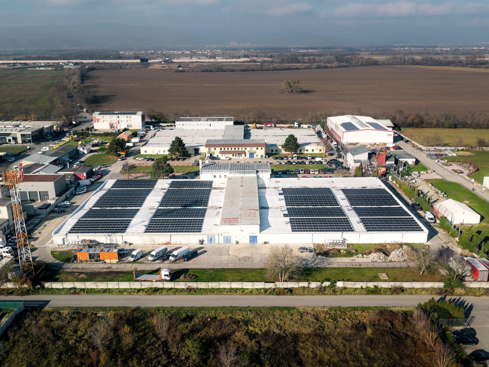 SKK-REAL industrial site in Ivanka pri Dunaji, halls with solar panels and fields around