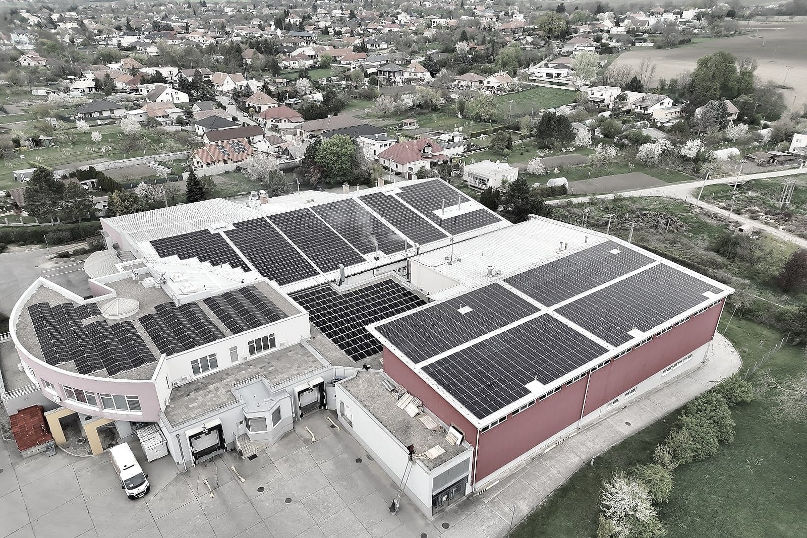 Orthophoto of a production site with rooftop solar PV, surrounded by a village and fields