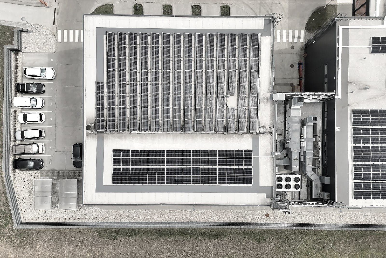 Top-down orthophoto of a production hall with rooftop solar PV, car park and canopy